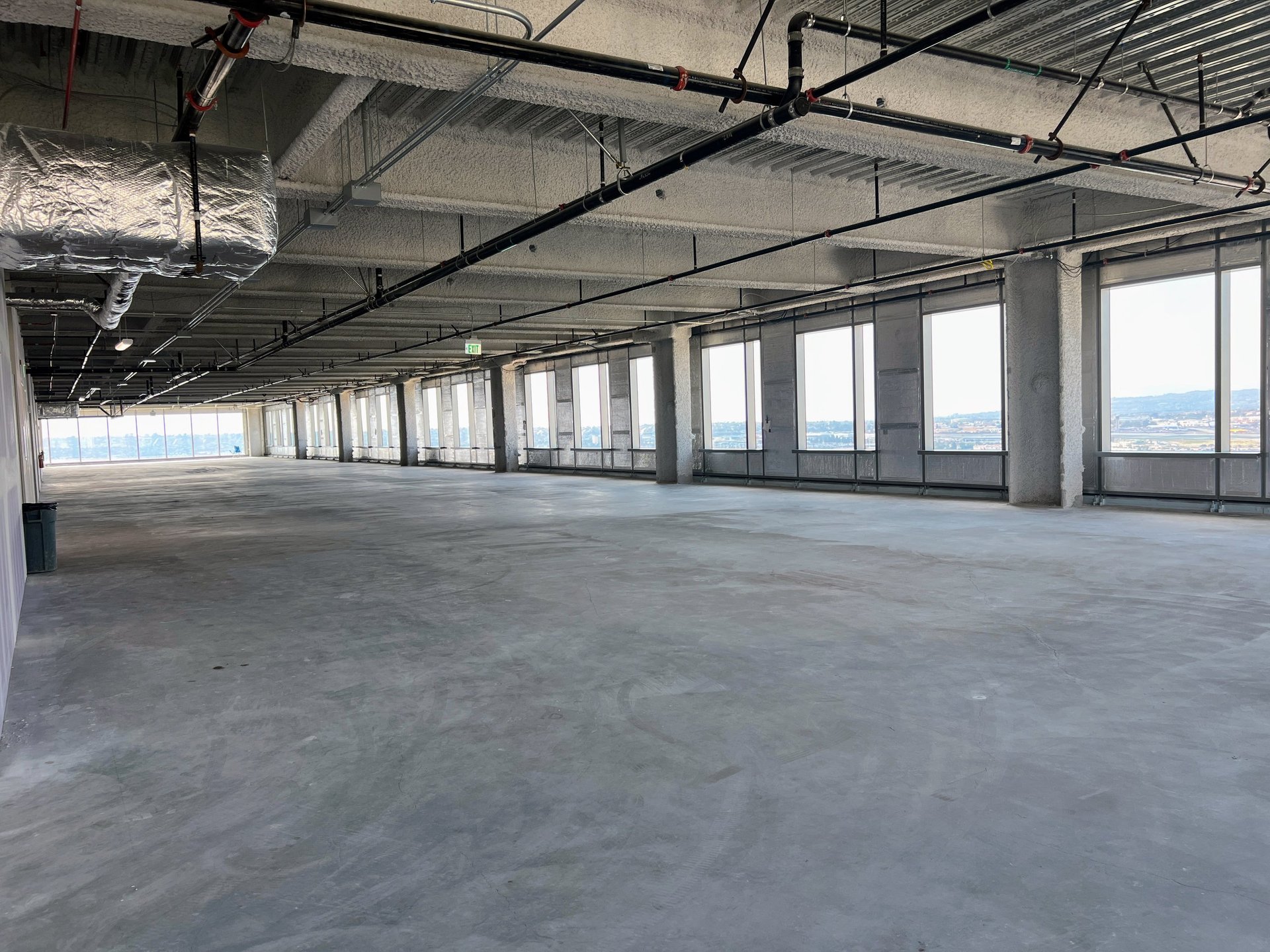 Empty commercial property space in shell condition with exposed beams